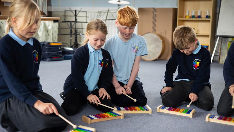 Four children playing the glockenspiel.