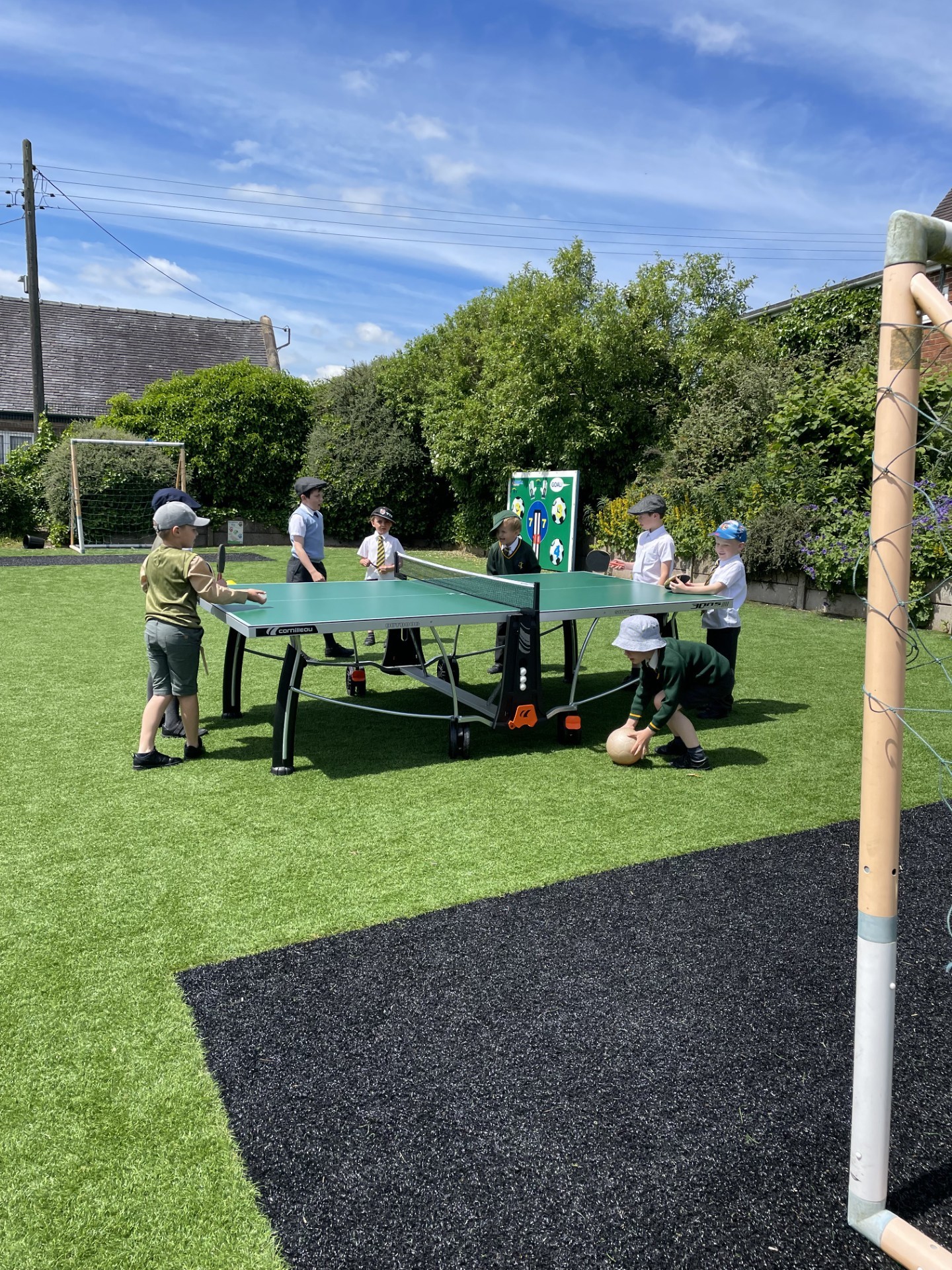 Children playing table tennis on the school playground.
