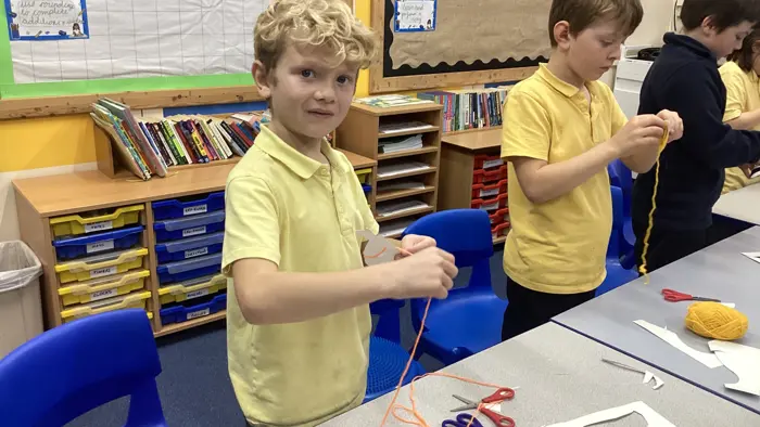 Children using wool in a DT lesson.