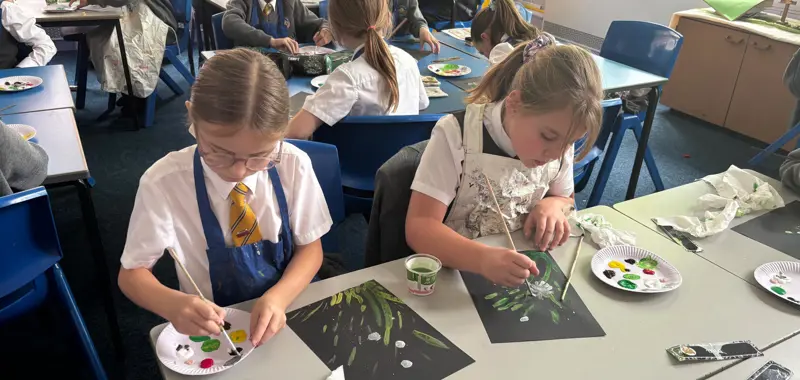 Two children painting flowers.