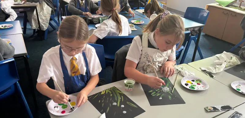 Two children painting flowers.