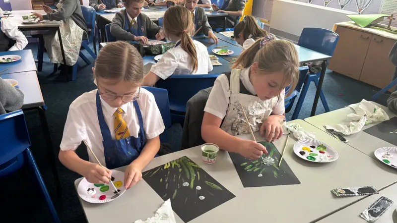 Two children painting flowers.