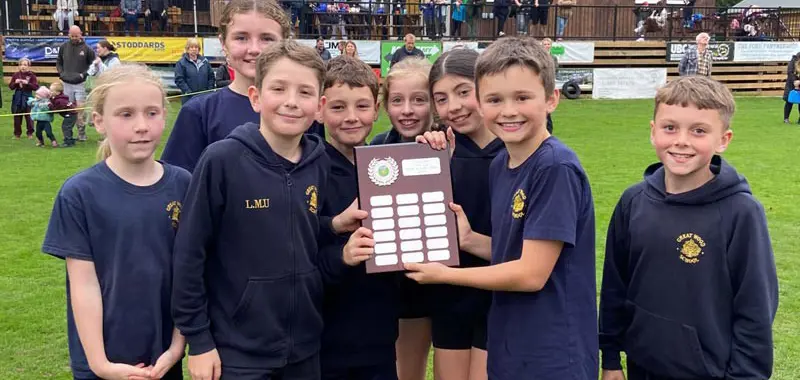 Great Wood Primary School cross country team holding a trophy.