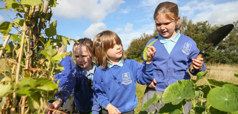 Three children gardening.