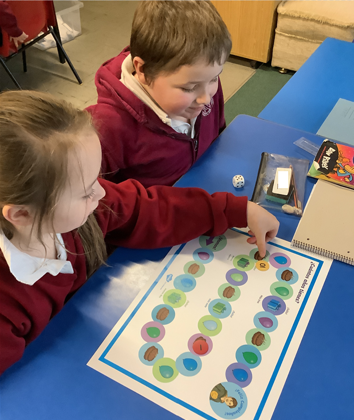 Two children playing an educational board game.