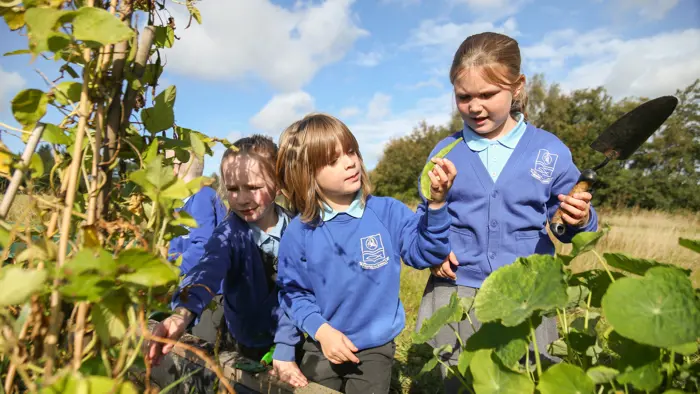 Three children gardening.