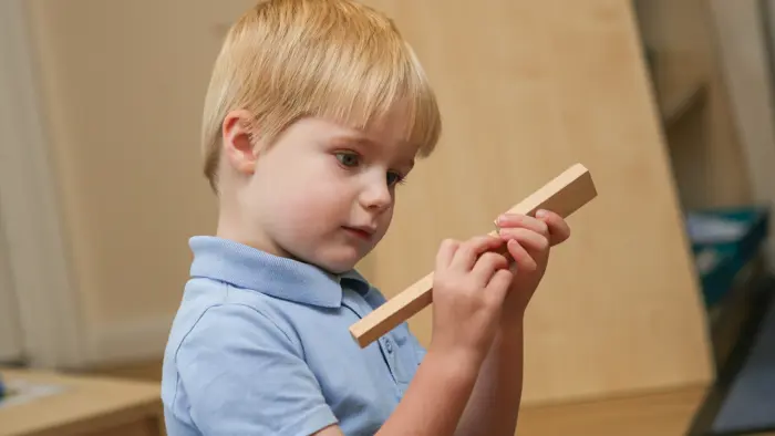 Younger child holding blocks.