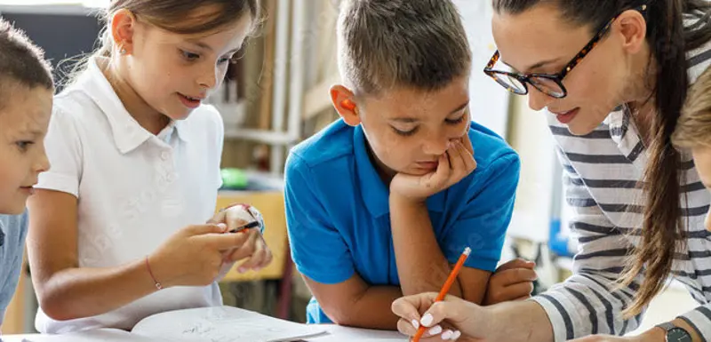 Teacher writing with four children.