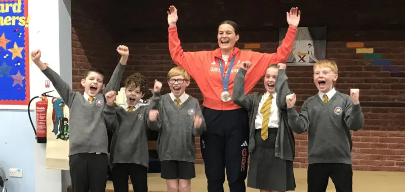 Children cheering with an Olympic medallist.