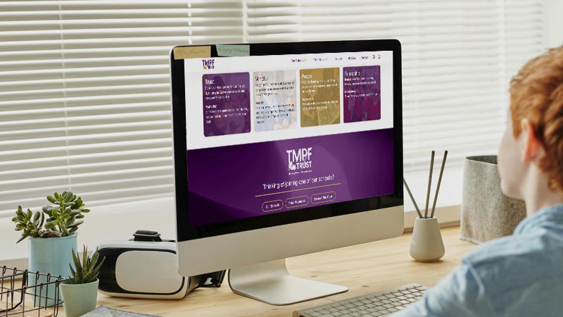 Child looking at the TMPF Trust website on a computer screen.