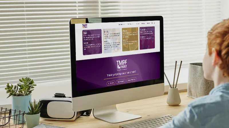 Child looking at the TMPF Trust website on a computer screen.