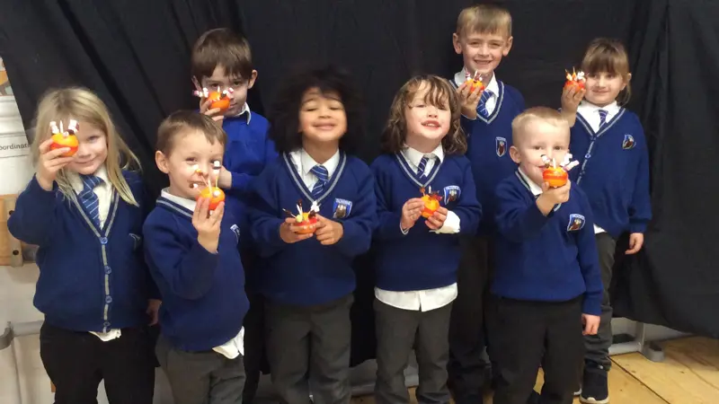Eight children holding Christingles