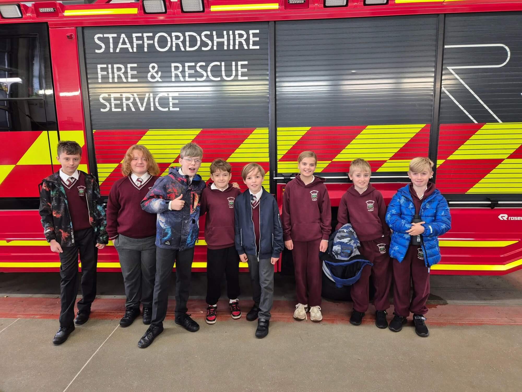 Children standing in front of a fire engine.