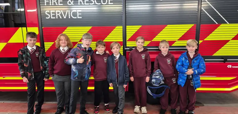 Children standing in front of a fire engine.