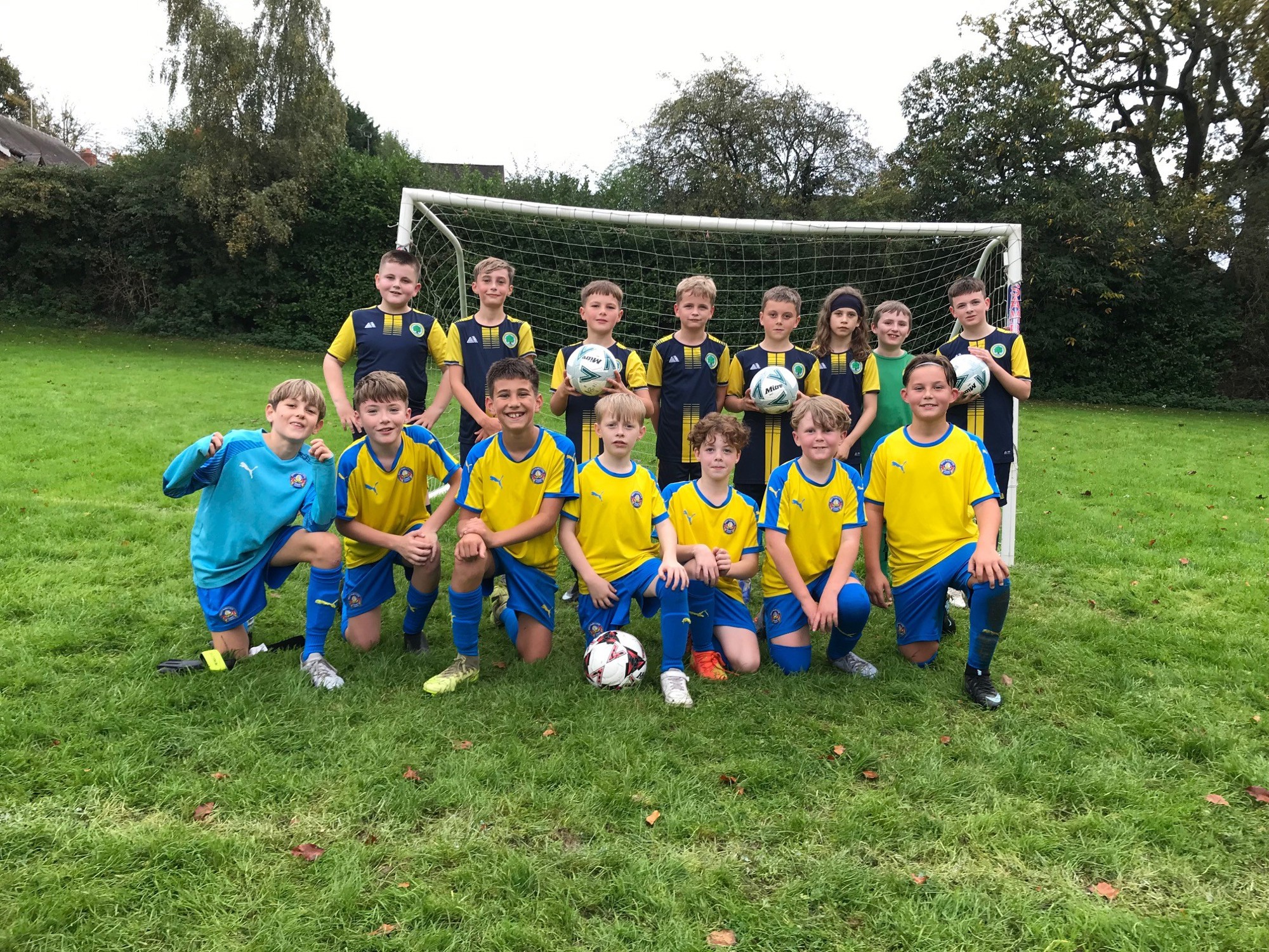 Two school football teams smiling together.