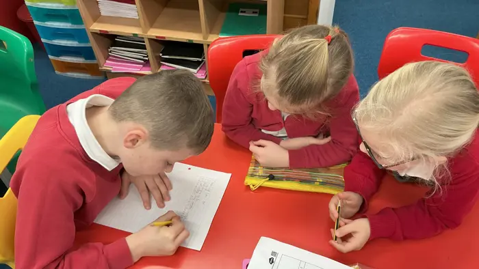 Three children learning together in class.