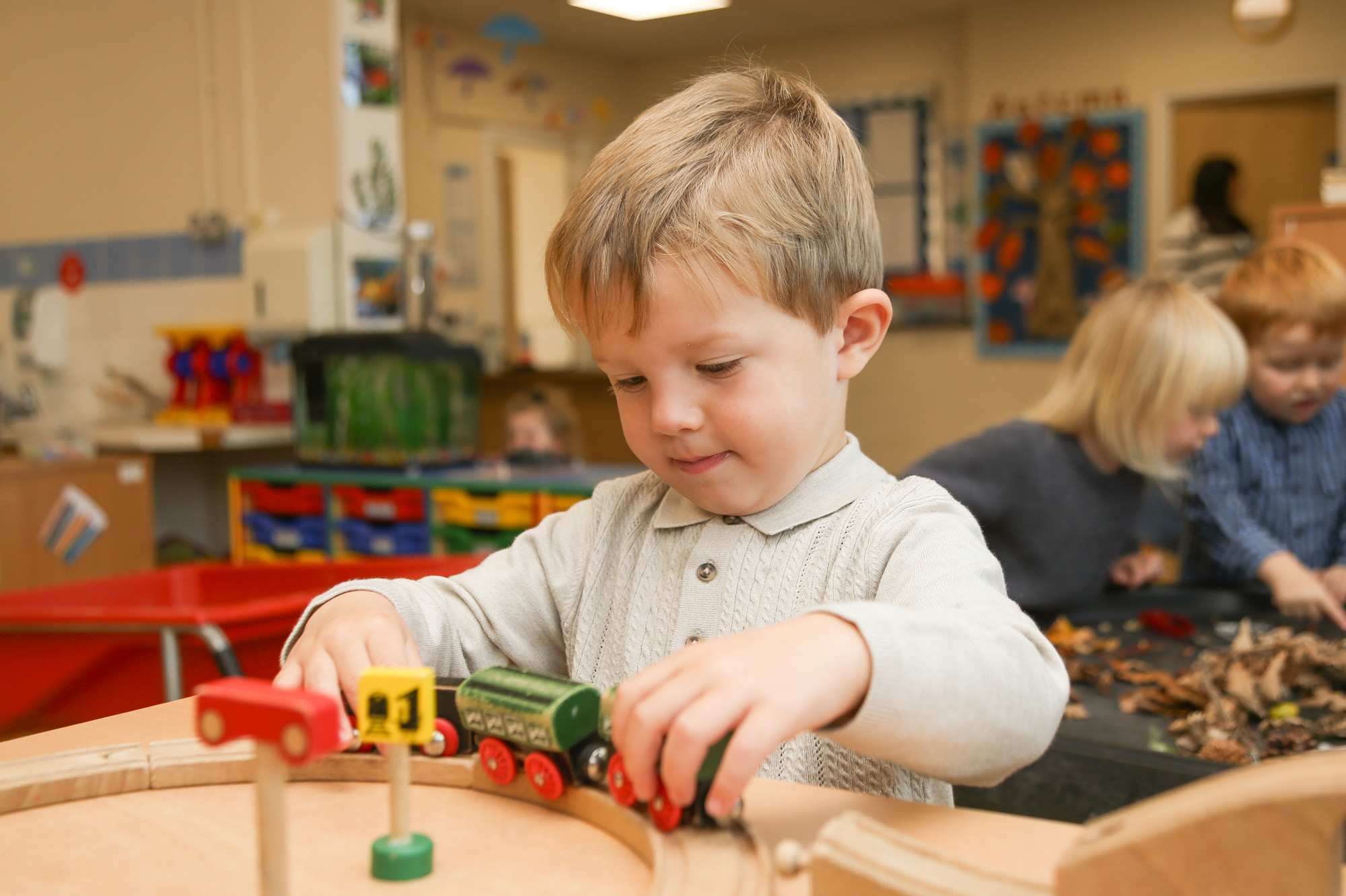 Younger child playing with a train.