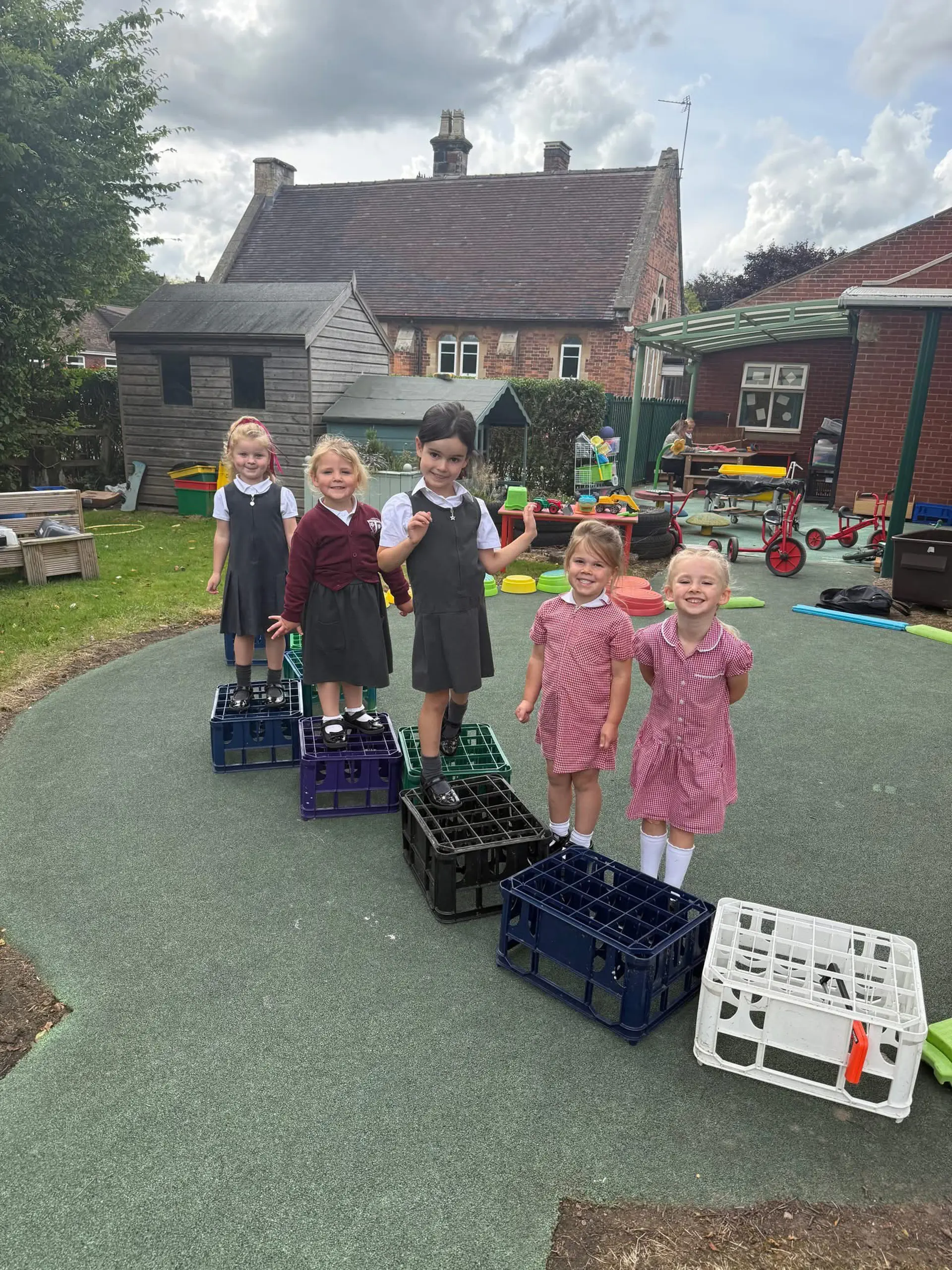 Five children playing with crates.