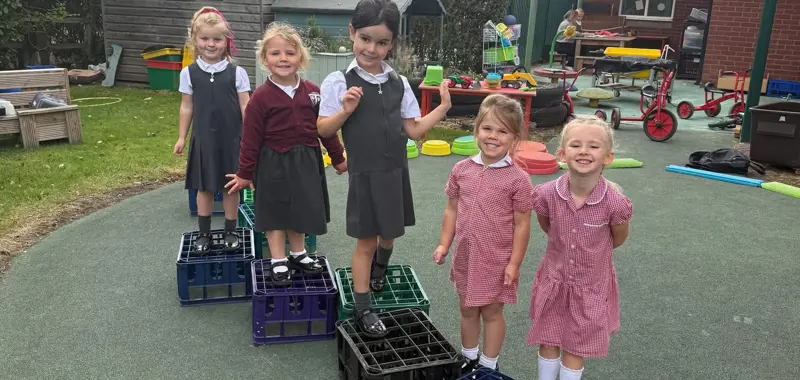 Five children playing with crates.