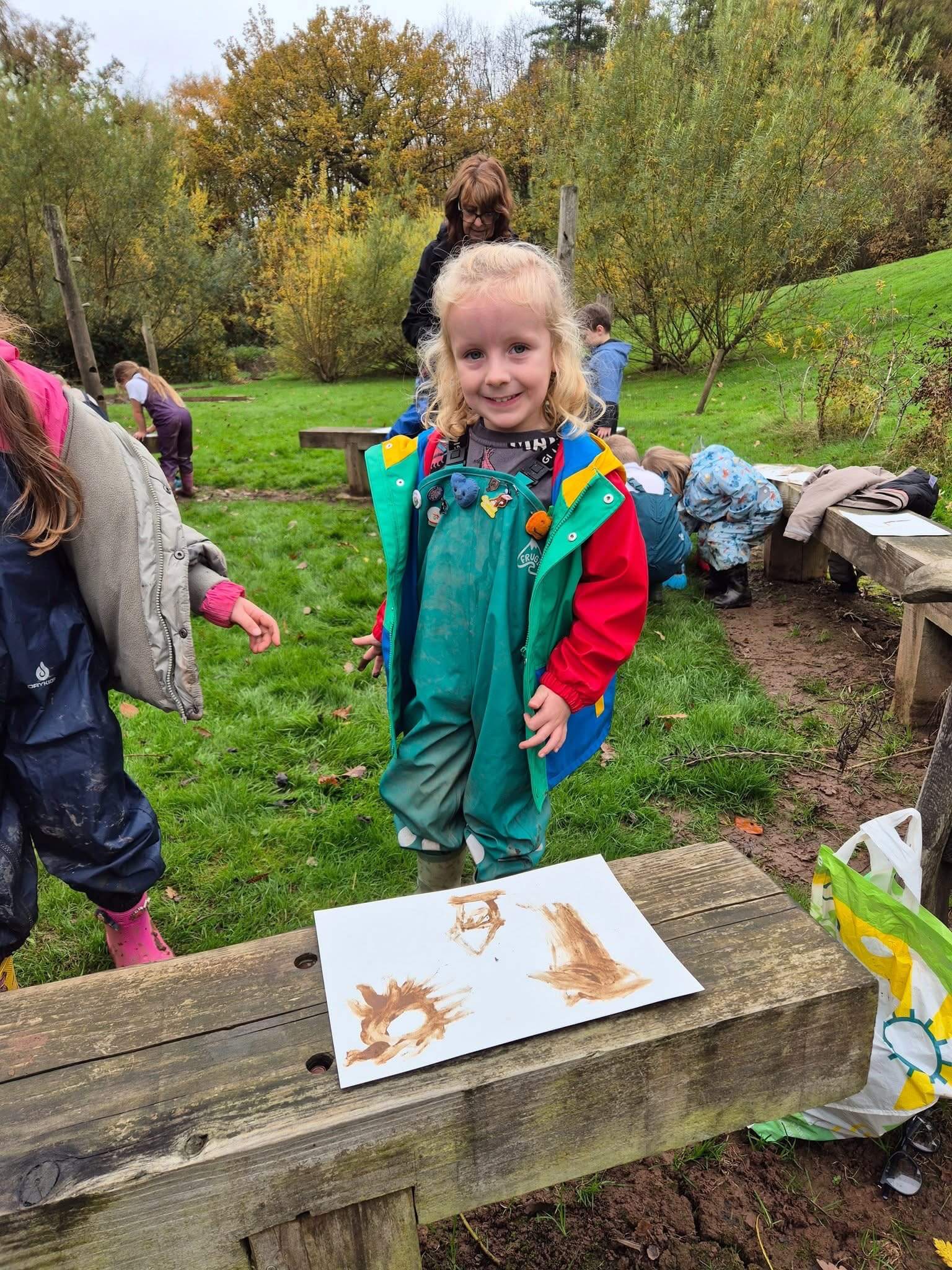 Child smiling at a Forest School session.