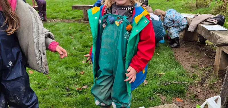 Child smiling at a Forest School session.