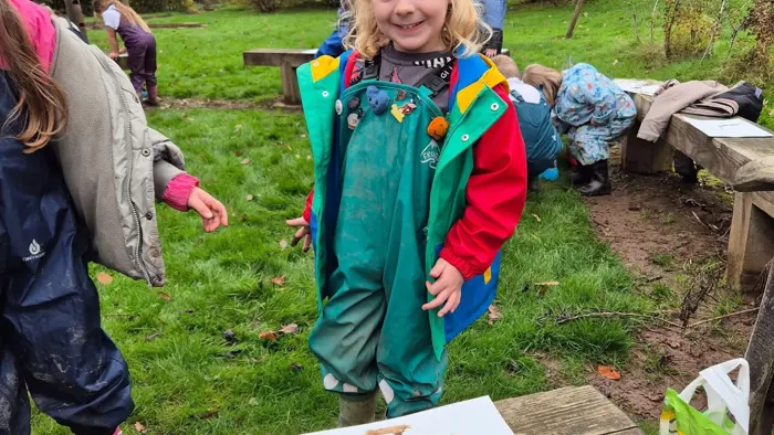 Child smiling at a Forest School session.