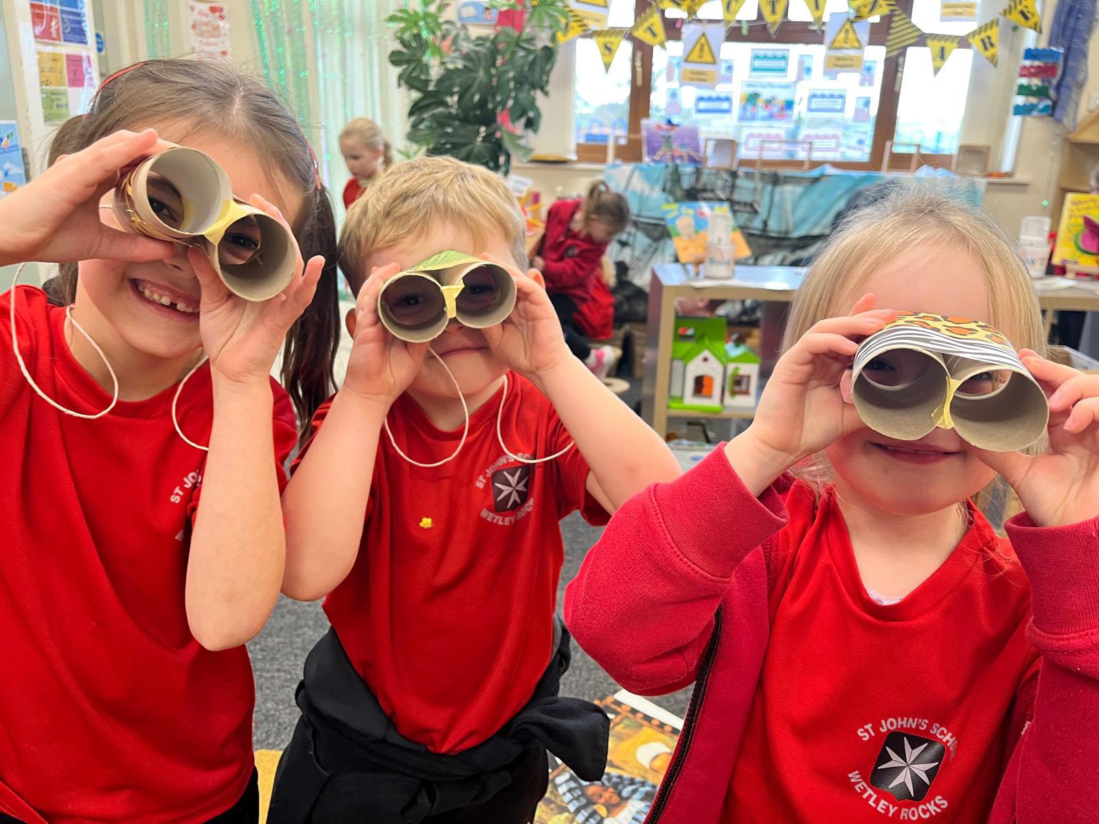 Three children with self-made binoculars.