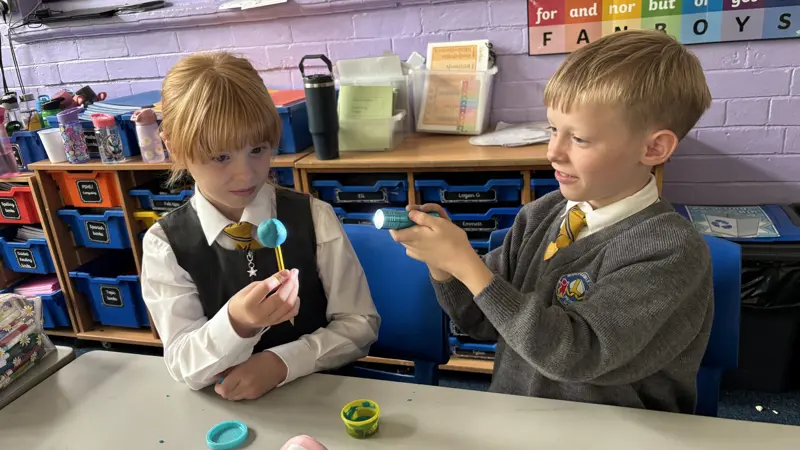 Two children using a torch in a Science lesson.
