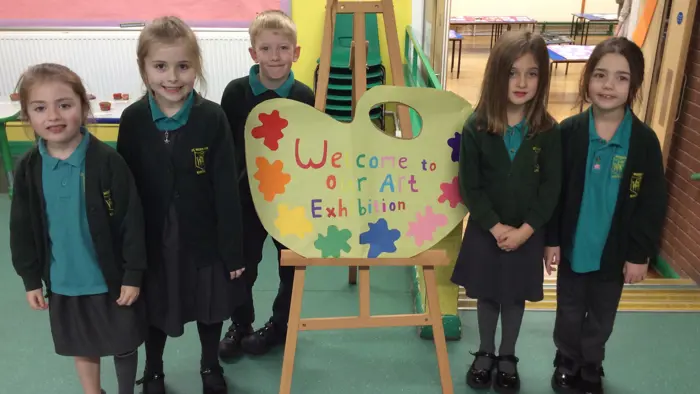 Group of children with a 'Welcome' sign.
