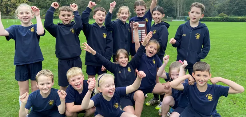 Children celebrating winning a trophy for cross country.