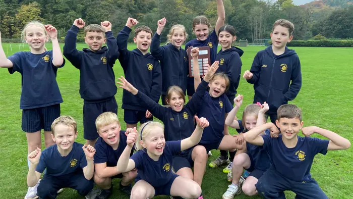 Children celebrating winning a trophy for cross country.