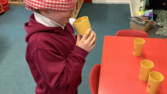 Child blind-tasting different drinks.
