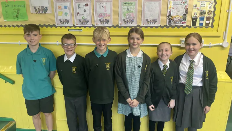 Six children smiling to the camera.