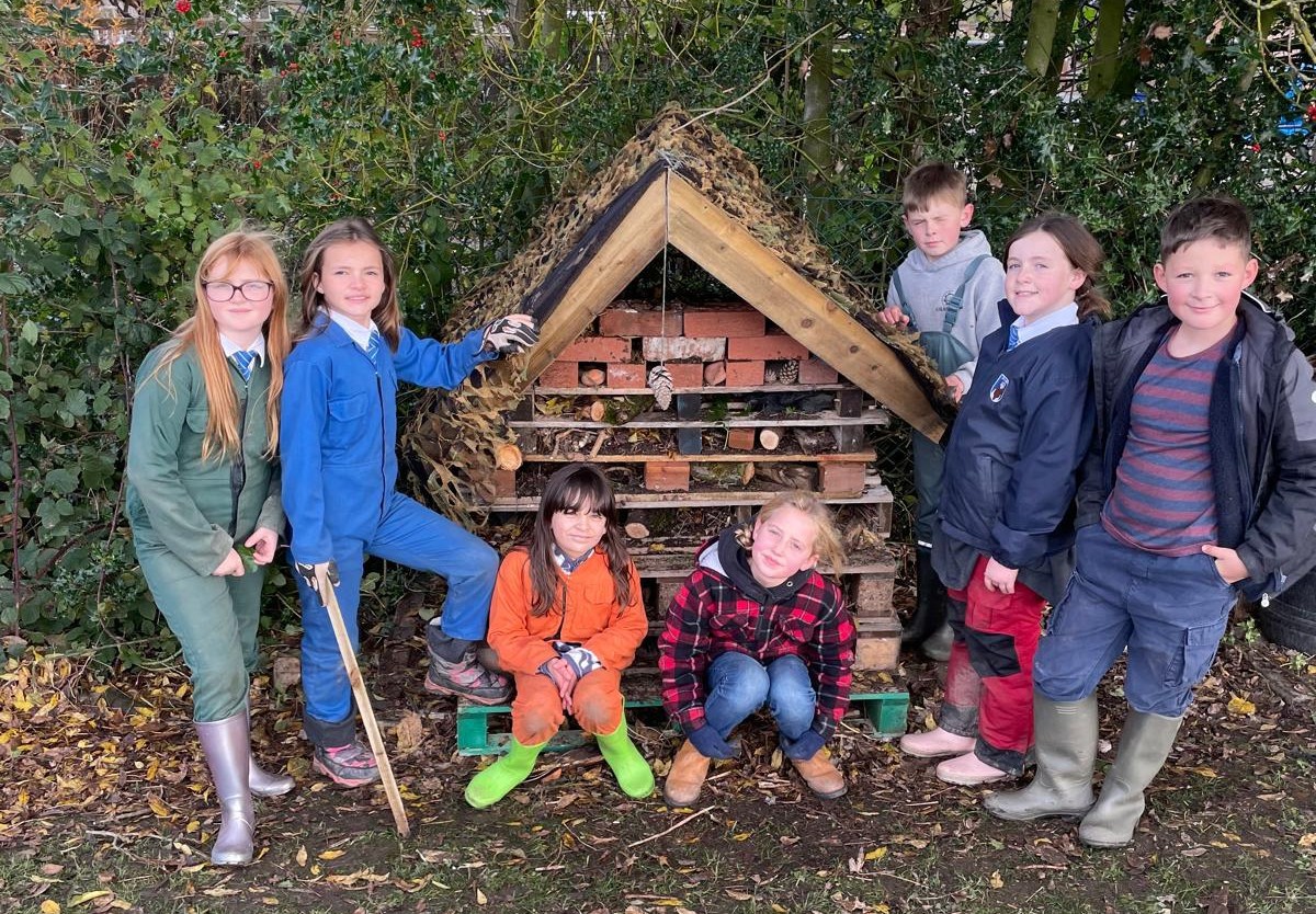 Children next to the bug hotel which they have helped to build.