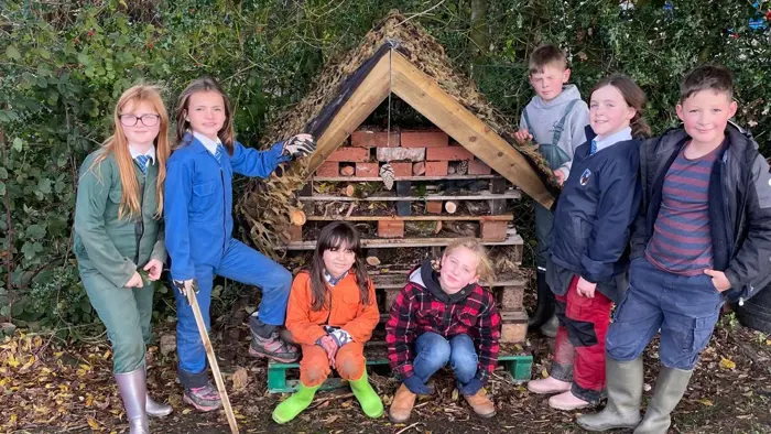 Children next to the bug hotel which they have helped to build.