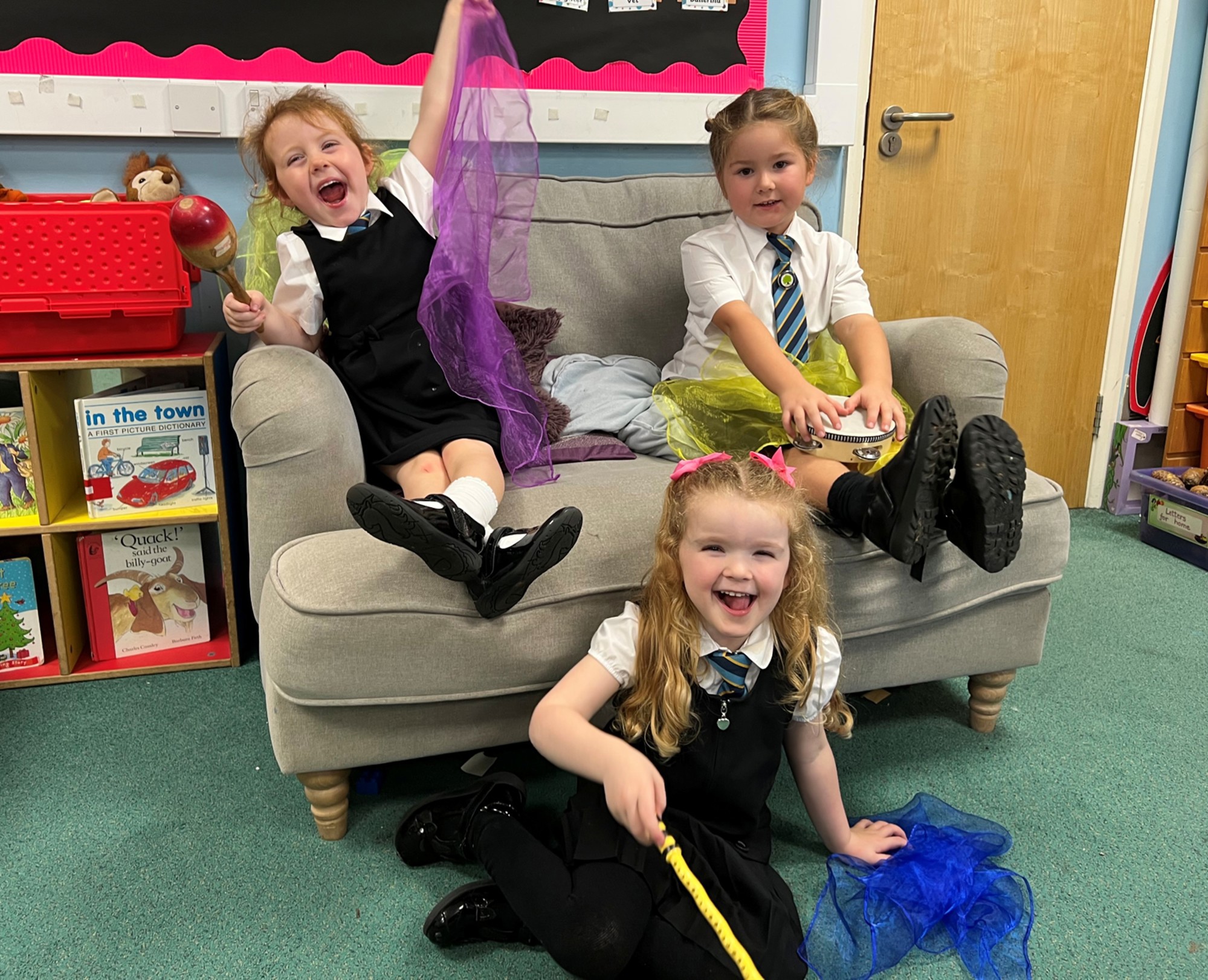 Three younger children sitting and smiling.