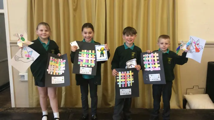 Four children holding artwork focusing upon peace and being mindful.