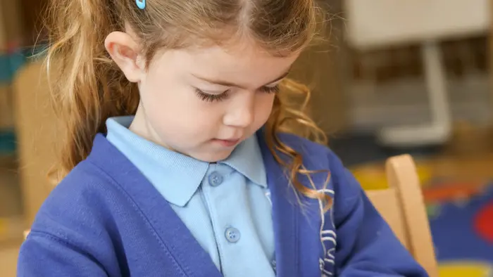 Child using Maths apparatus.