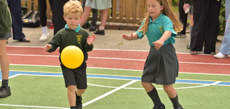 Two younger children playing with a ball.
