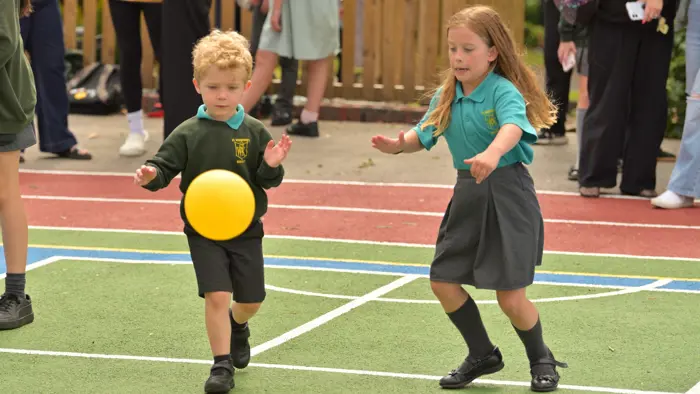 Two younger children playing with a ball.