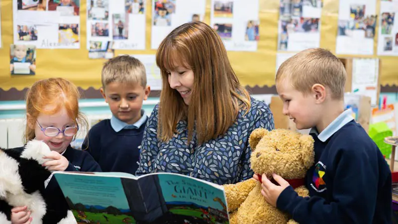 Teacher reading with three children.
